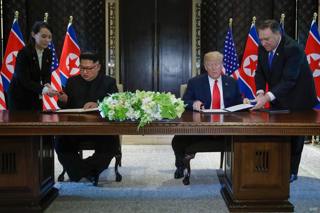 President Donald Trump and North Korea's Kim Jong Un sign a document following their summit in Singapore.
